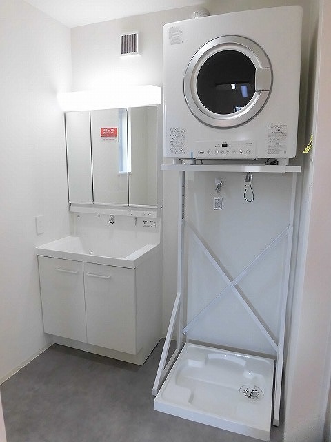 シャワー付き洗面台と洗濯機置き場、ガス乾燥機があります。